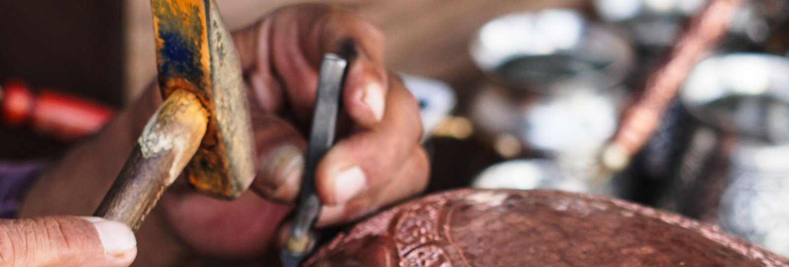 Nepali craftsman hand-chasing a copper bowl in a Kathmandu workshop